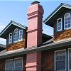Custom Masonry Brick Chimney with two brick corbel projections and extensive brick corbelling just below the chimney cap and spark arrestor